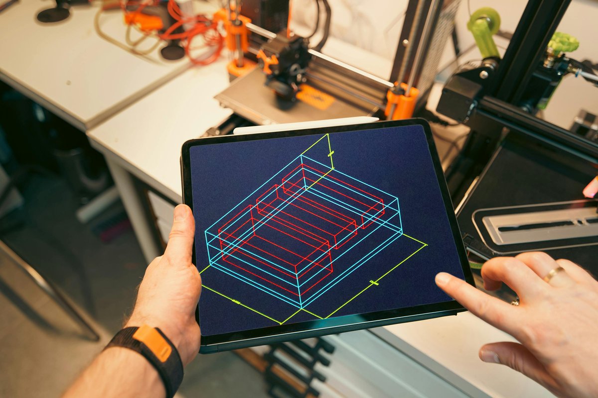 two hands holding a tablet with custom CAD design on the screen