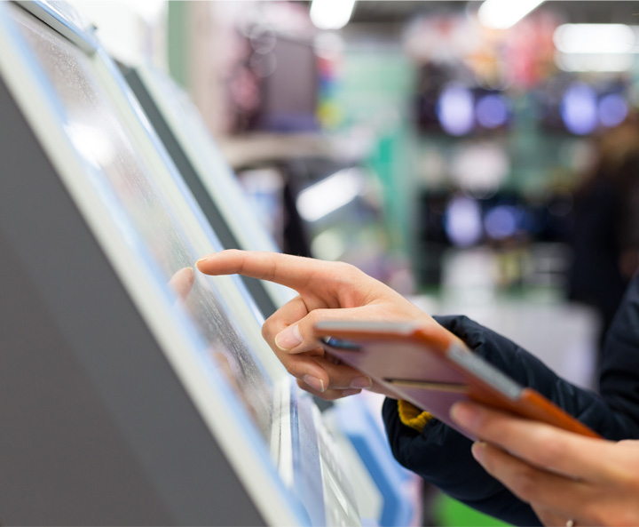 hand with finger touching a touch screen electronic and other hand holding a smartphone