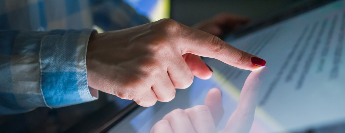 hand with finger touching a touch screen electronic