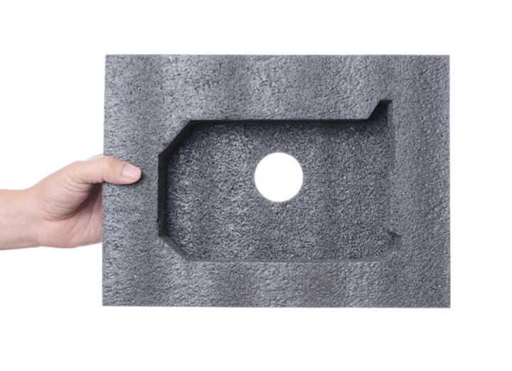 hand holding black material with custom cut compartment in it
