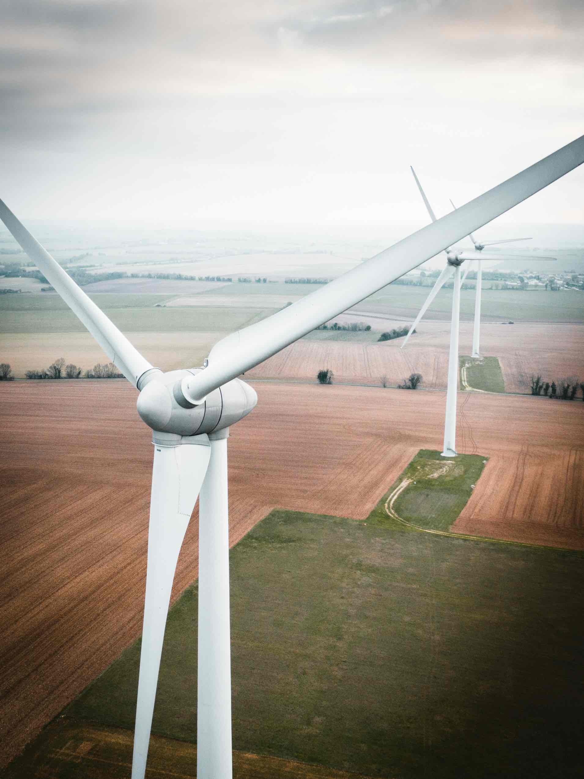 close up of wind turbine on a farm, with others in distance